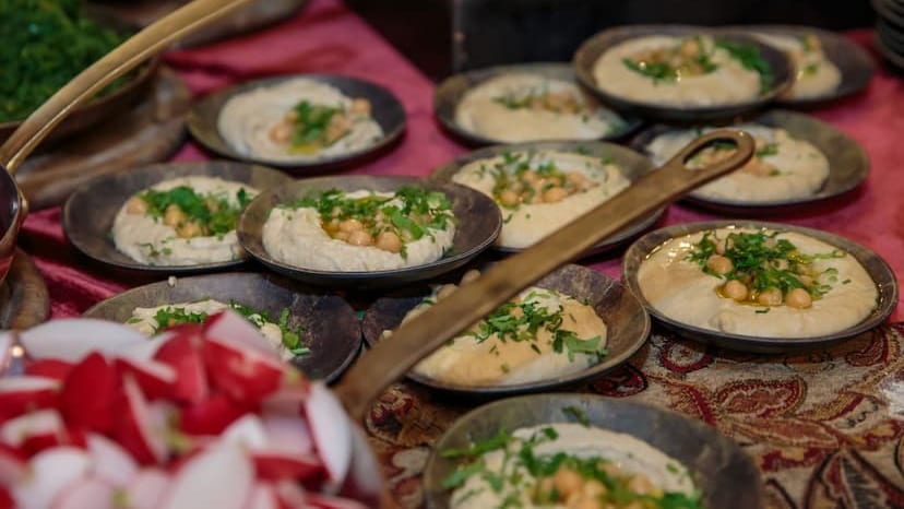 A vibrant display of hummus garnished with parsley and chickpeas in a traditional setting.