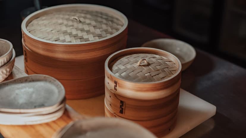 Close-up of bamboo steamers in warm light, showcasing traditional Asian kitchenware.