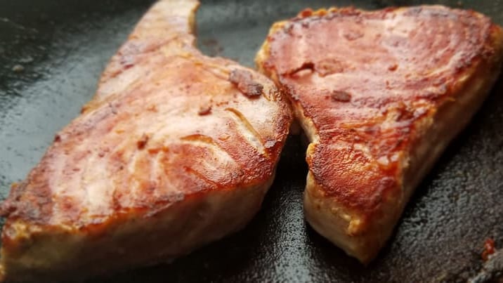 Close-up of perfectly grilled tuna steaks, showcasing the rich, savory texture.